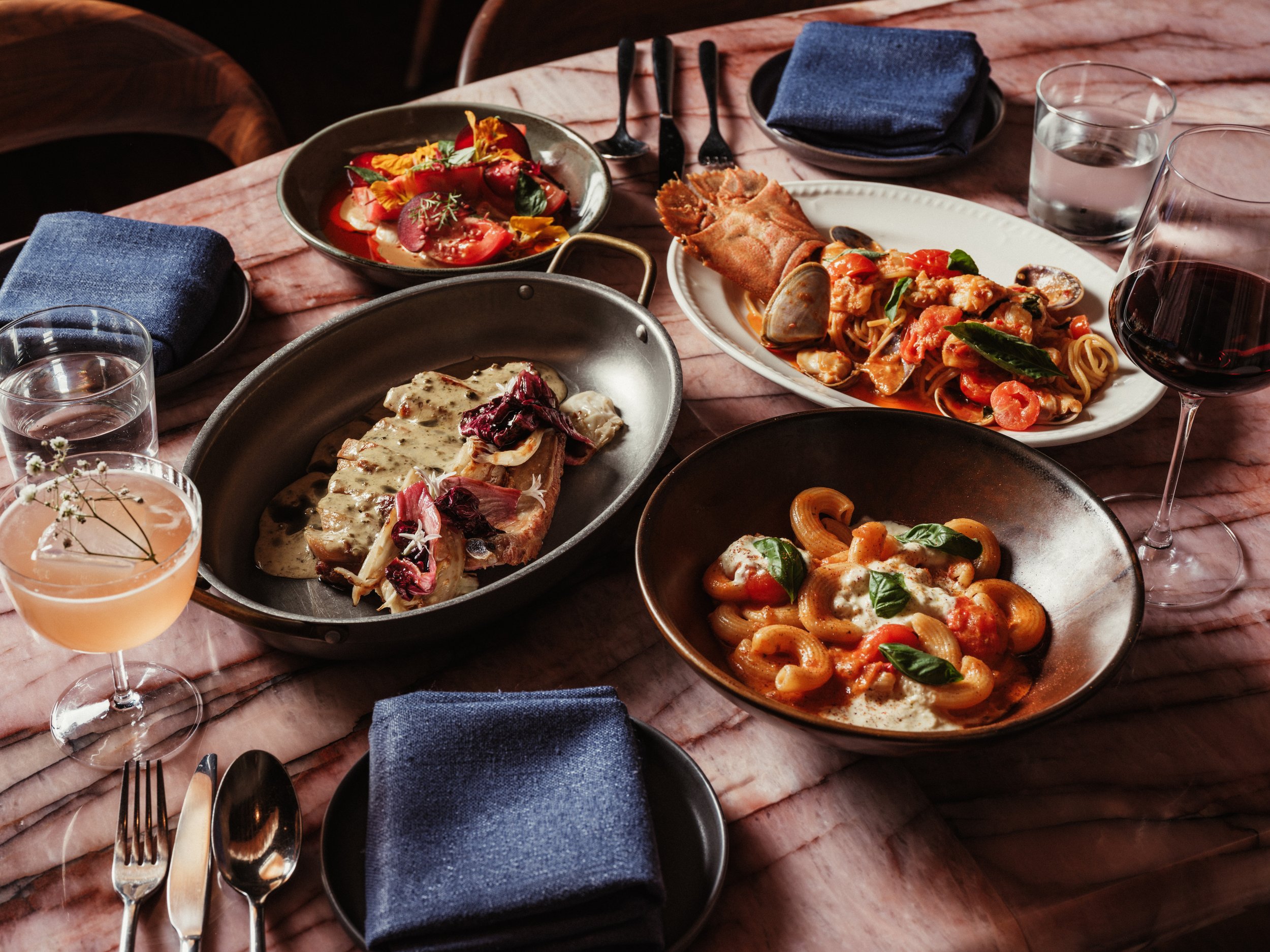 Shared plates and drinks set on a Lana table